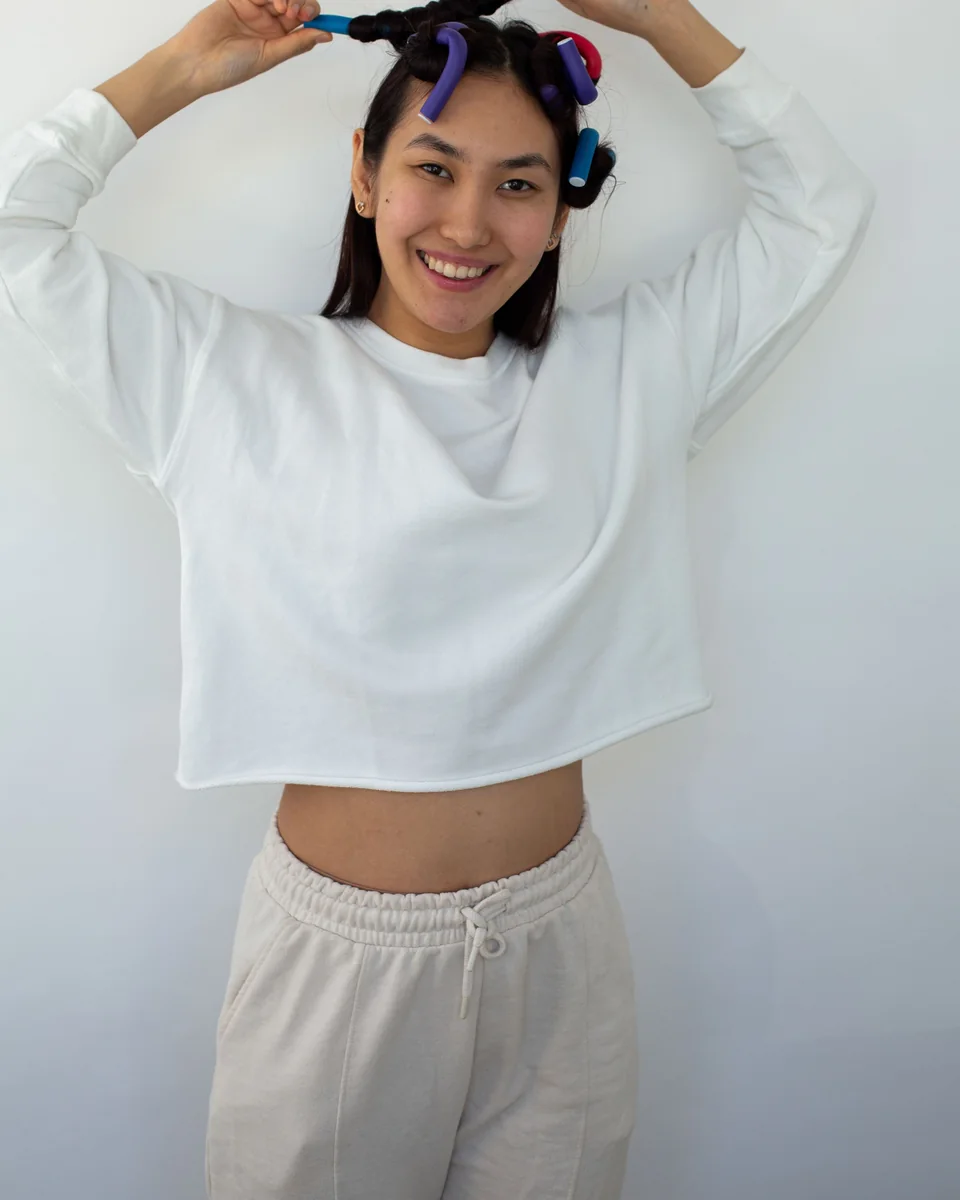 Model wearing a white cropped sweatshirt with cream joggers