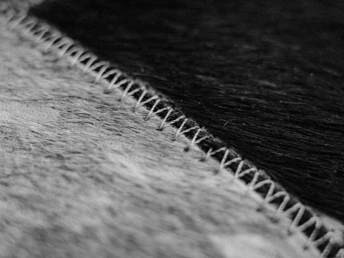 Close-up of a flat zig-zag seam joining grey and black fleece fabric