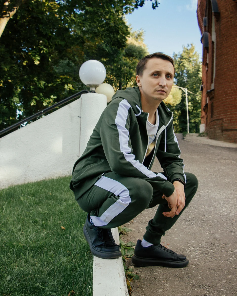 Model wearing a green full-zip sweatsuit jacket with matching joggers