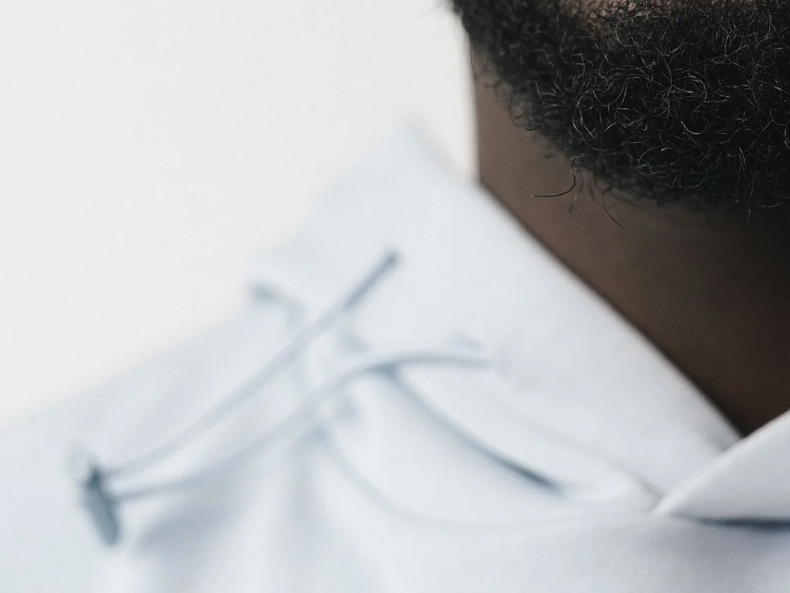Hoodie drawcords threaded through the hood eyelets, close-up
