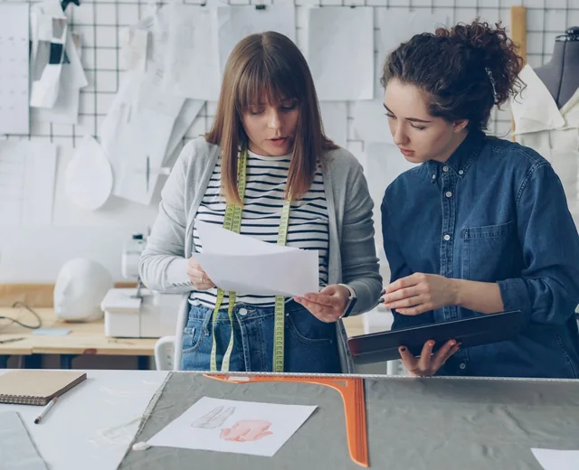 Sale Smart Sports team reviewing a garment tech pack and pattern in the sampling studio