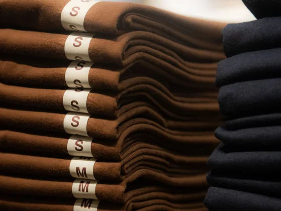 Low MOQ garment run folded and stacked by size label at Sale Smart Sports
