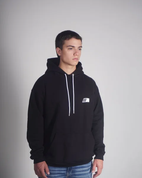 Model wearing a plain black streetwear hoodie ready for private label branding