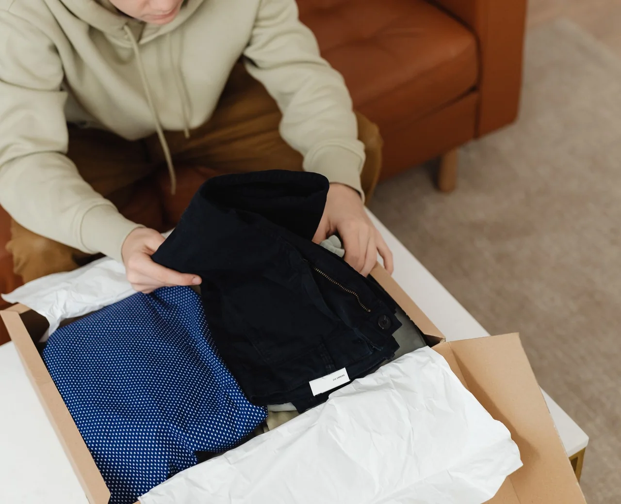 Folded garments packed with tissue paper in a cardboard shipping box