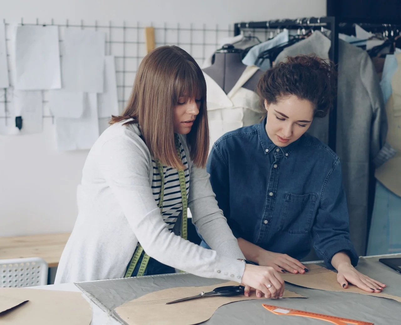 Designers reviewing a streetwear tech pack and pattern files before cutting