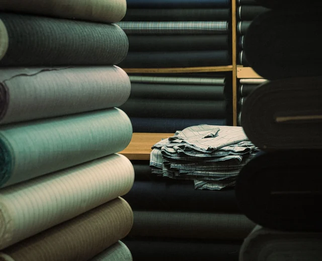 Stacked rolls of fabric on warehouse shelves ready for cutting