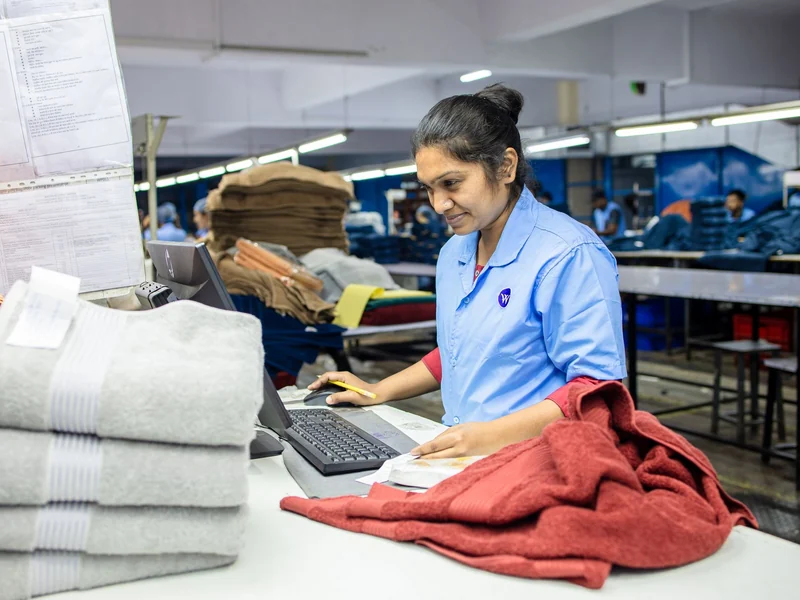 Quality inspector checking finished goods and logging results at an inspection table