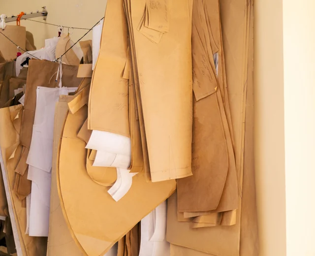Paper pattern pieces hanging in the pattern room of a cut and sew clothing manufacturer