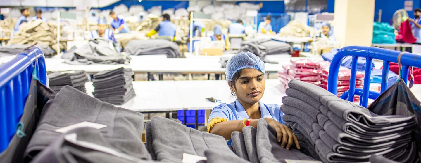 Worker sorting stacks of cut garment panels before they go to the sewing line