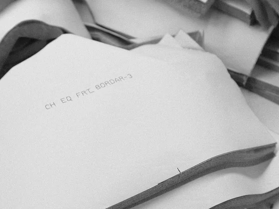 Stack of cut fabric panels marked with pencil, ready to be bundled for sewing