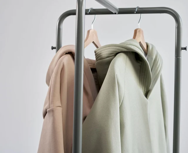 Finished hoodies hanging on a clothing rack after production