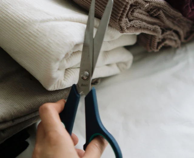 Rolls of wool, corduroy and cotton fabric with tailor scissors for jacket shells and linings