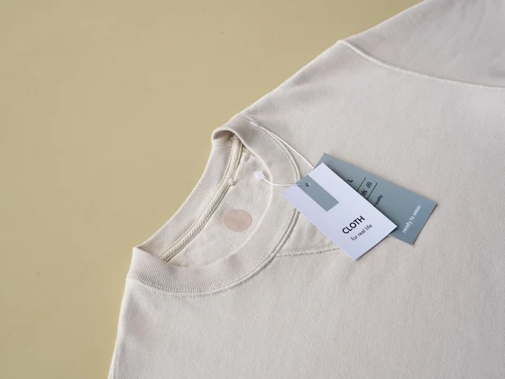 Cream sweatshirt neckline with blank brand tags attached for private label branding