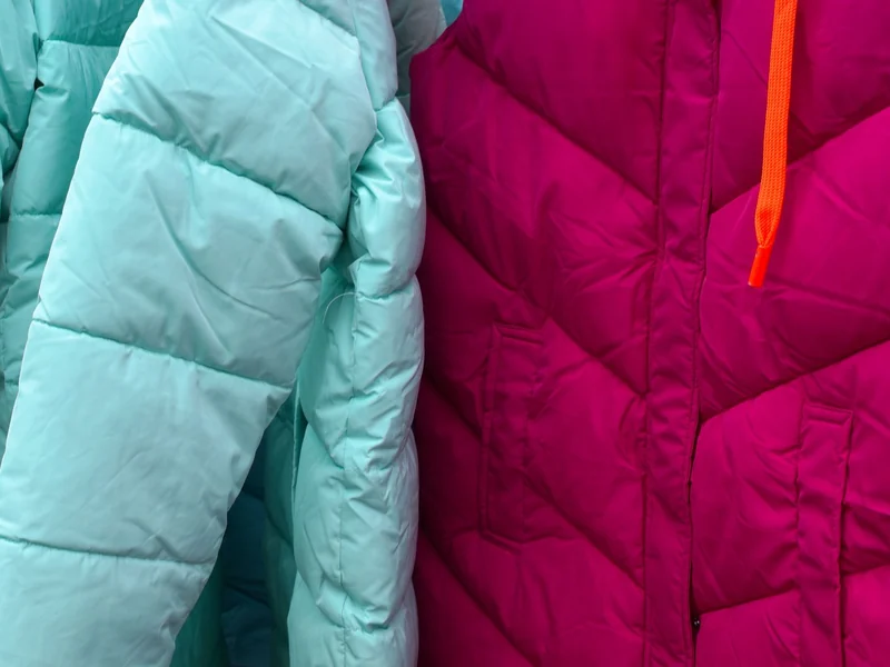 Close-up of quilted padded jackets in turquoise and magenta shells