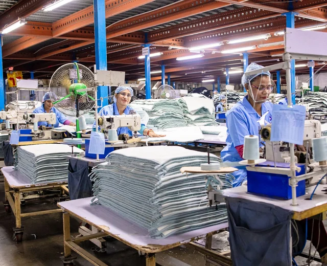 Sewing operators on a garment factory floor, the kind of production line a varsity jacket manufacturer runs